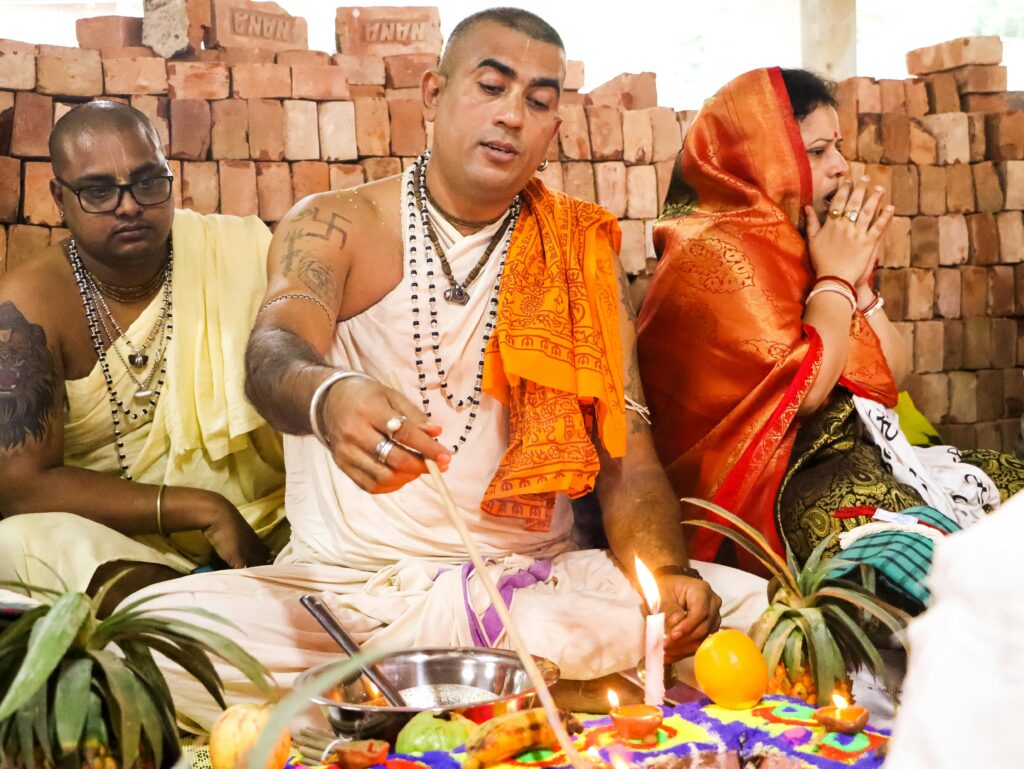 Priests performing a Hindu ritual in Dhaka, showcasing vibrant cultural traditions.