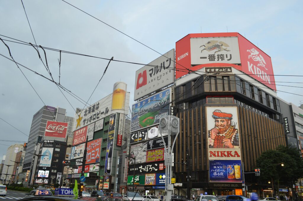 Bustling cityscape at Sapporo's Susukino Intersection showcasing vibrant billboards and urban architecture.