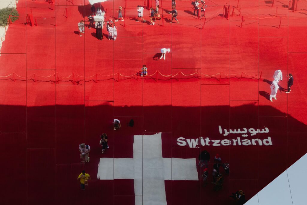 A mirrored view of the Swiss Pavilion with a cross and red pattern at the Expo.