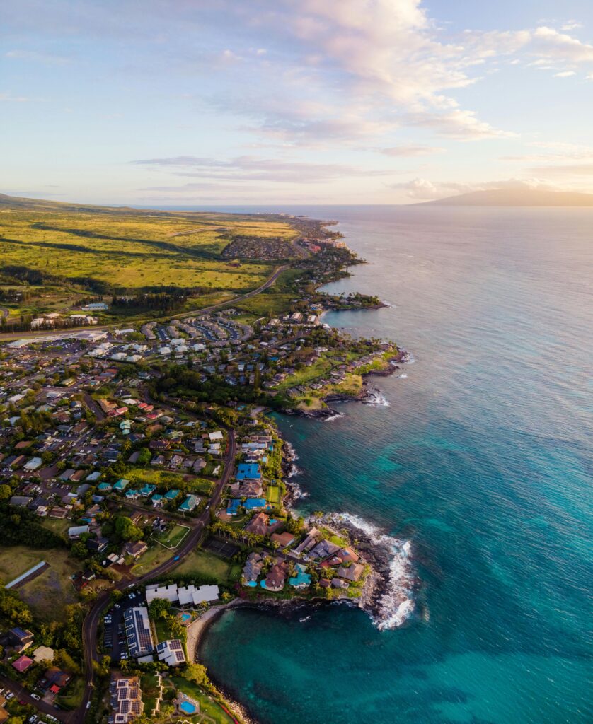 Stunning aerial shot of Lahaina, Hawaii coastline during sunset, showcasing vibrant townscape and ocean views.