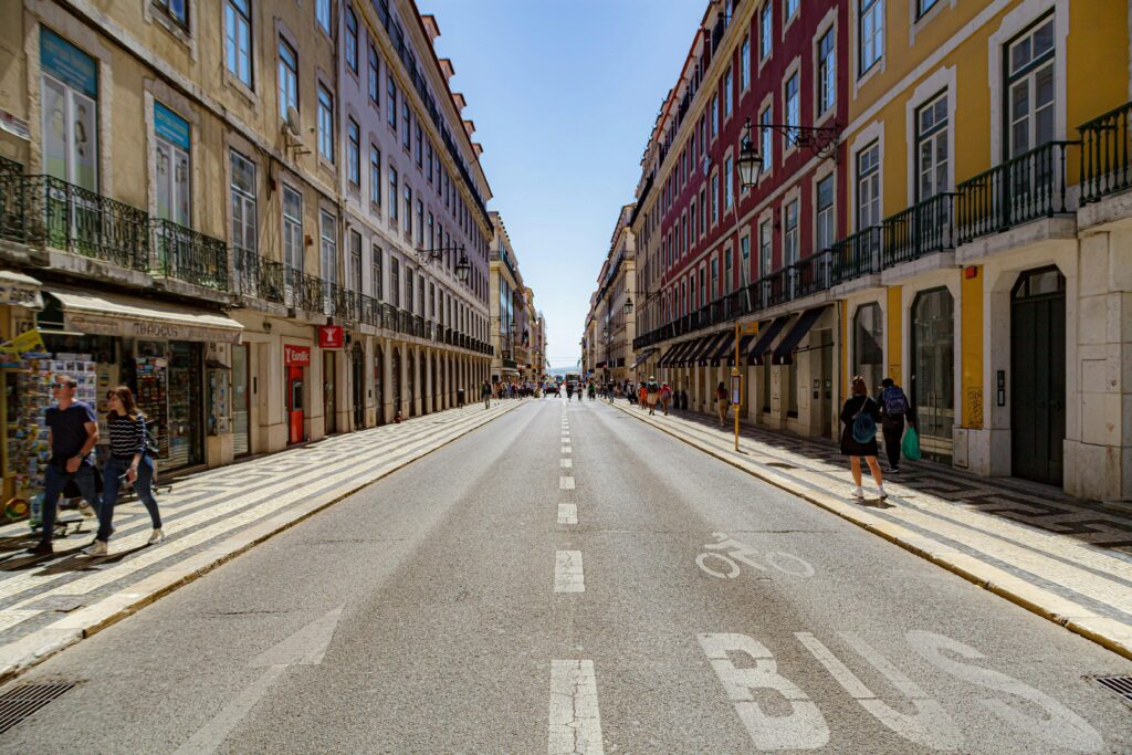 A bustling street in Lisbon showcasing colorful historic buildings and urban life.