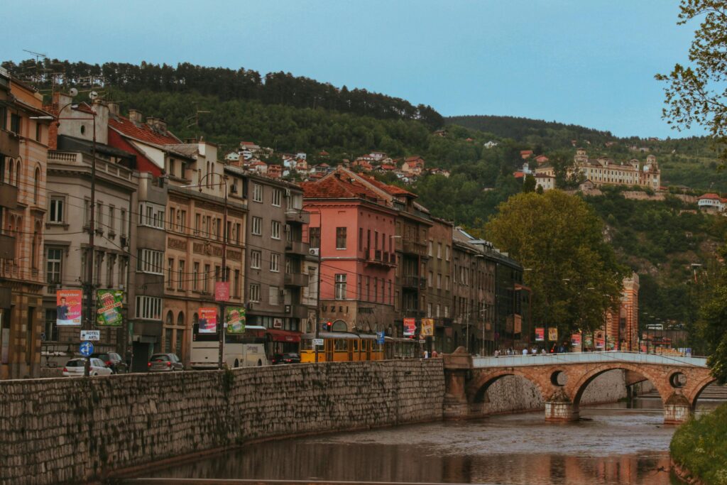 Explore the charming riverside architecture and historic bridge in Sarajevo, Bosnia and Herzegovina.