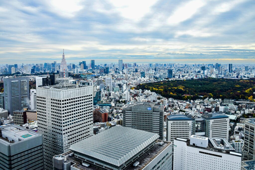 A panoramic view of Tokyo's skyline with high-rise buildings and lush green parkland.