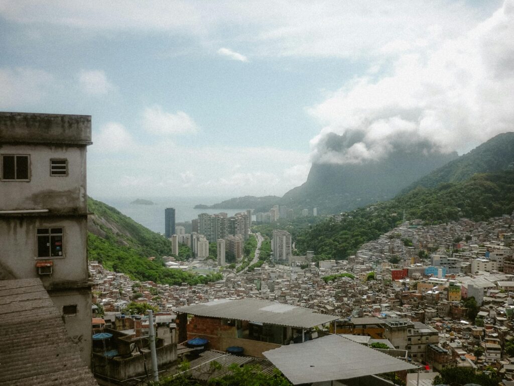 Aerial view of Rio de Janeiro with cityscape, mountains, and clouds.
