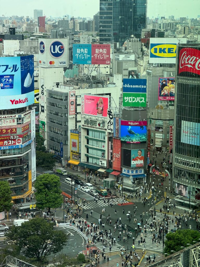 Busy and vibrant view of Shibuya Crossing in Tokyo with bustling crowds and iconic billboards.