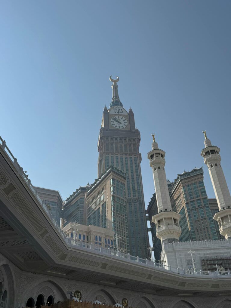 Stunning view of Abraj Al-Bait Towers under clear blue sky in Mecca, Saudi Arabia.