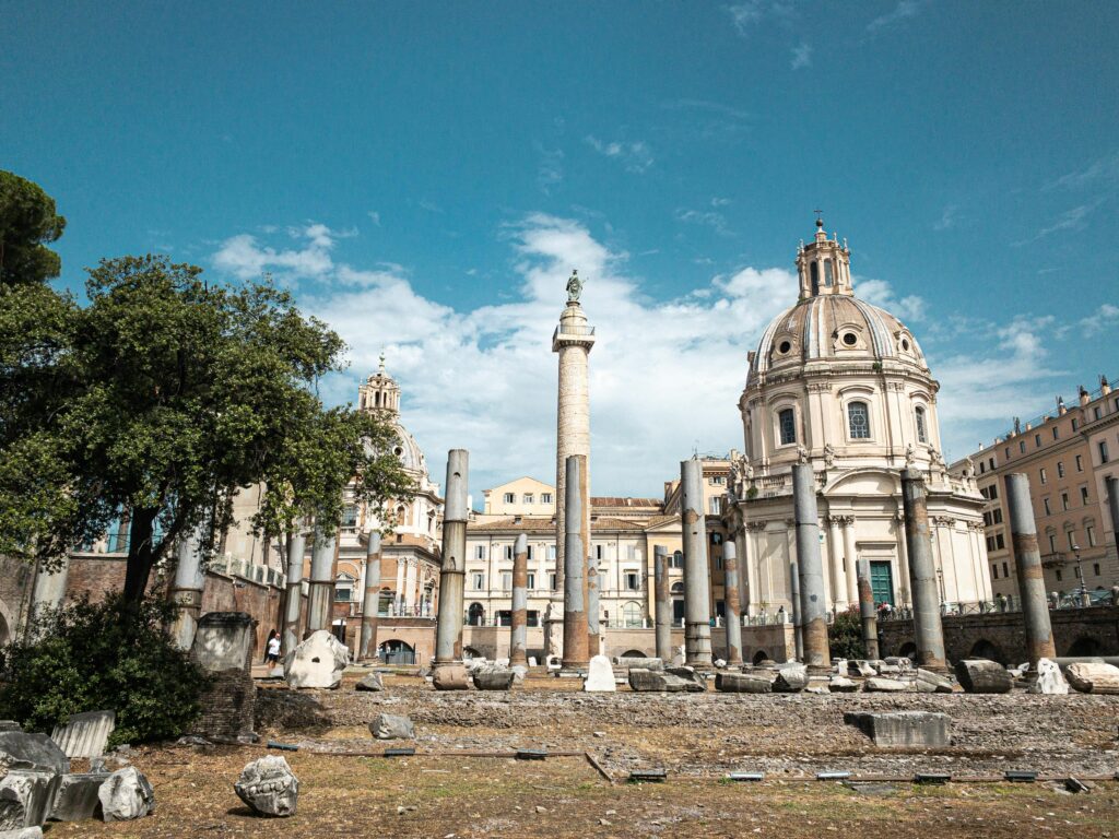 Scenic view of ancient Roman architecture in the heart of Rome, showcasing historical buildings and columns under a clear sky.