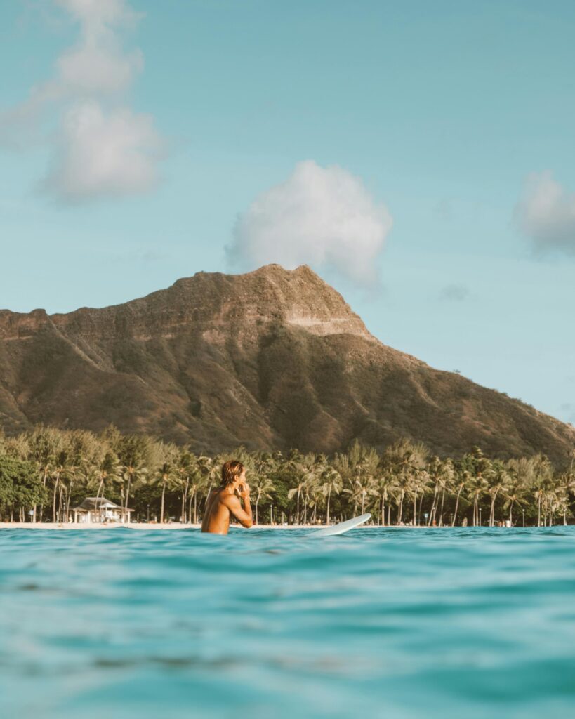Surfer in vibrant Hawaii ocean with iconic Diamond Head mountain backdrop. Perfect for travel and adventure themes.