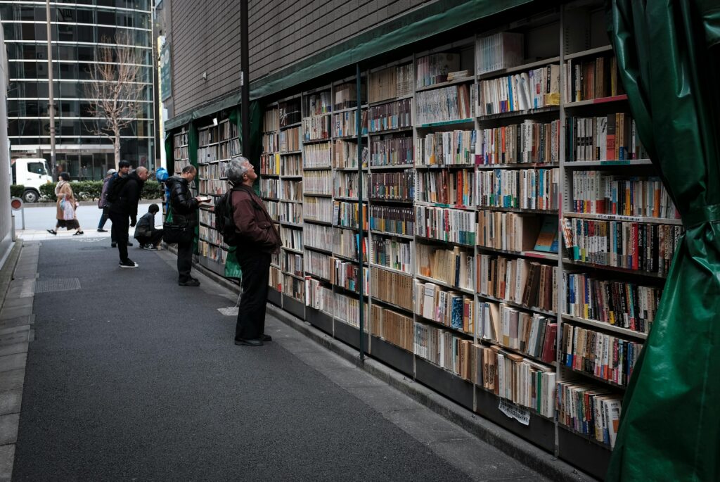 Outdoor bookshelves in Tokyo with people exploring literature on a city street.