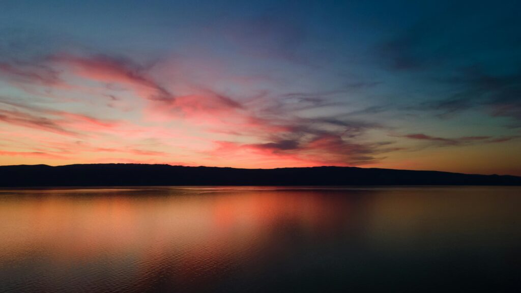 Dramatic sunset over Lake Baikal with reflections and colorful sky in Russia.