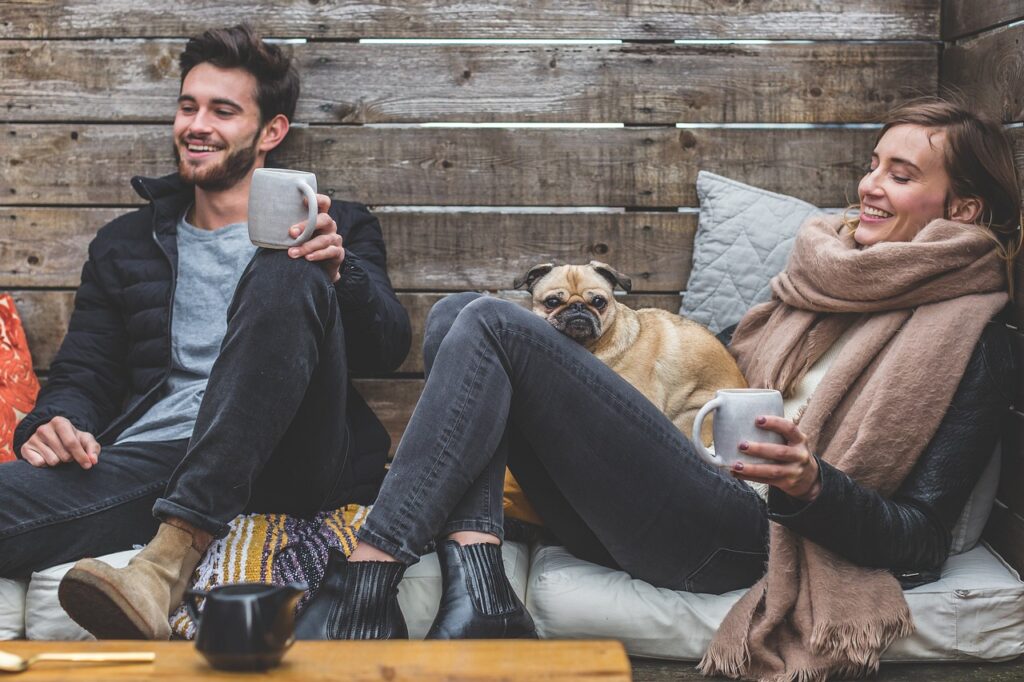 merry christmas, man, woman, dog, pet, pug, owners, couple, relationship, warm clothes, cozy, scarf, animal, jackets, jeans, boots, fashion, people, happy, love, female, young, male, adult, caucasian, happiness, romantic, portrait, smile, smiling, girlfriend, date, boyfriend, together, person, lovers, sitting, relaxing, rustic, cushions, couch, laughing, enjoying, coffee