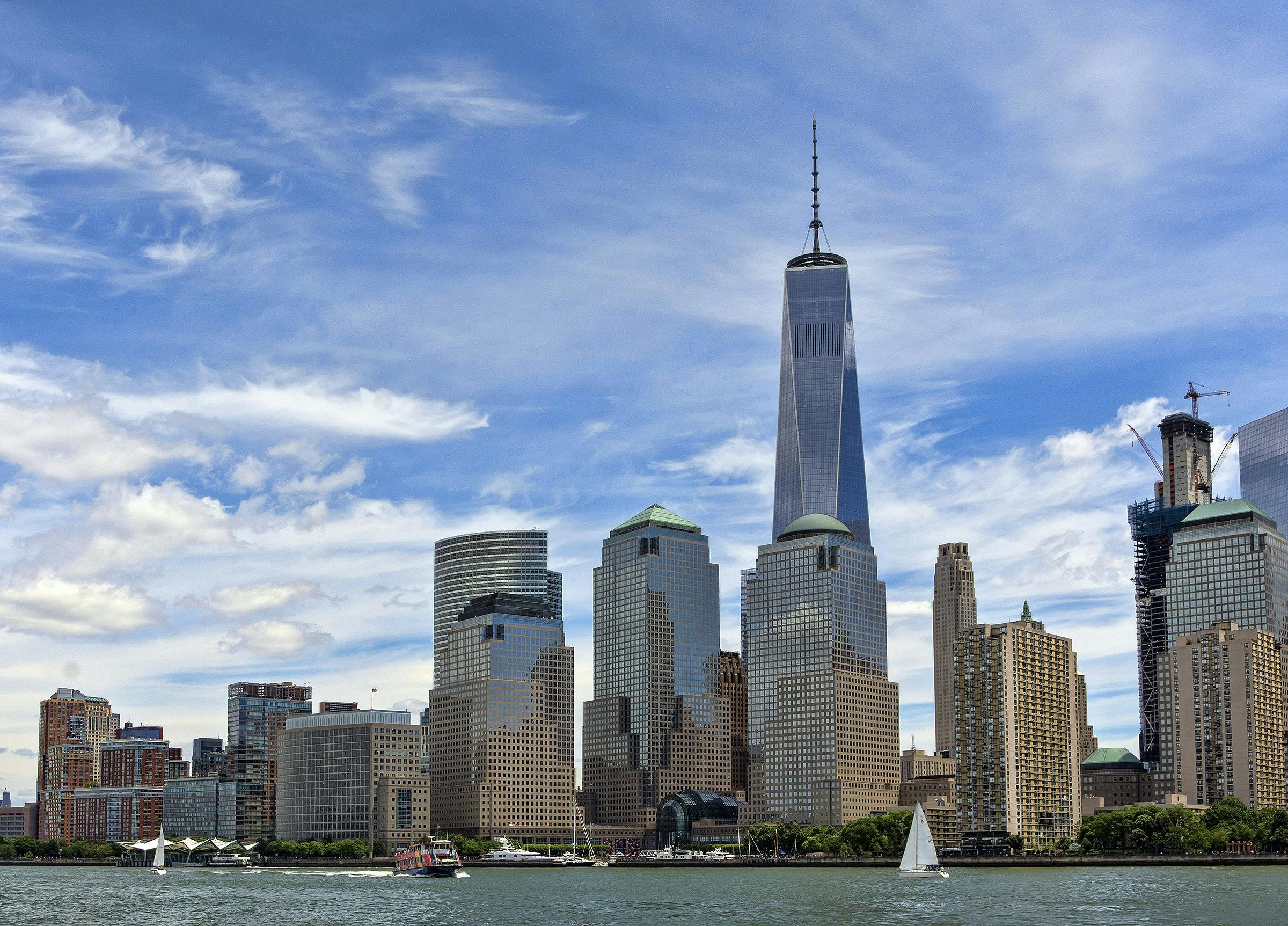 Iconic New York City skyline featuring One World Trade Center and vibrant waterfront view.