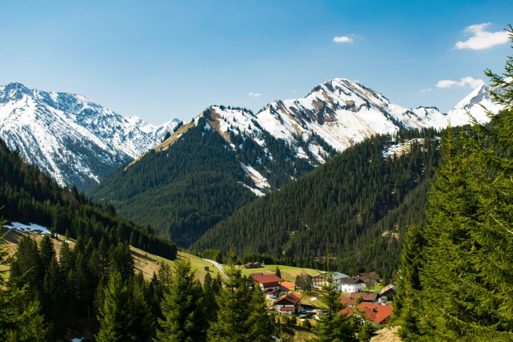 Idyllic village of Rinnen in Tirol, Austria, nestled among snow-capped Alps and lush forests. Perfect winter landscape.