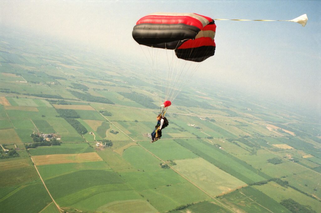 Experience the thrill of tandem parachuting with a bird's-eye view over lush Wisconsin fields.