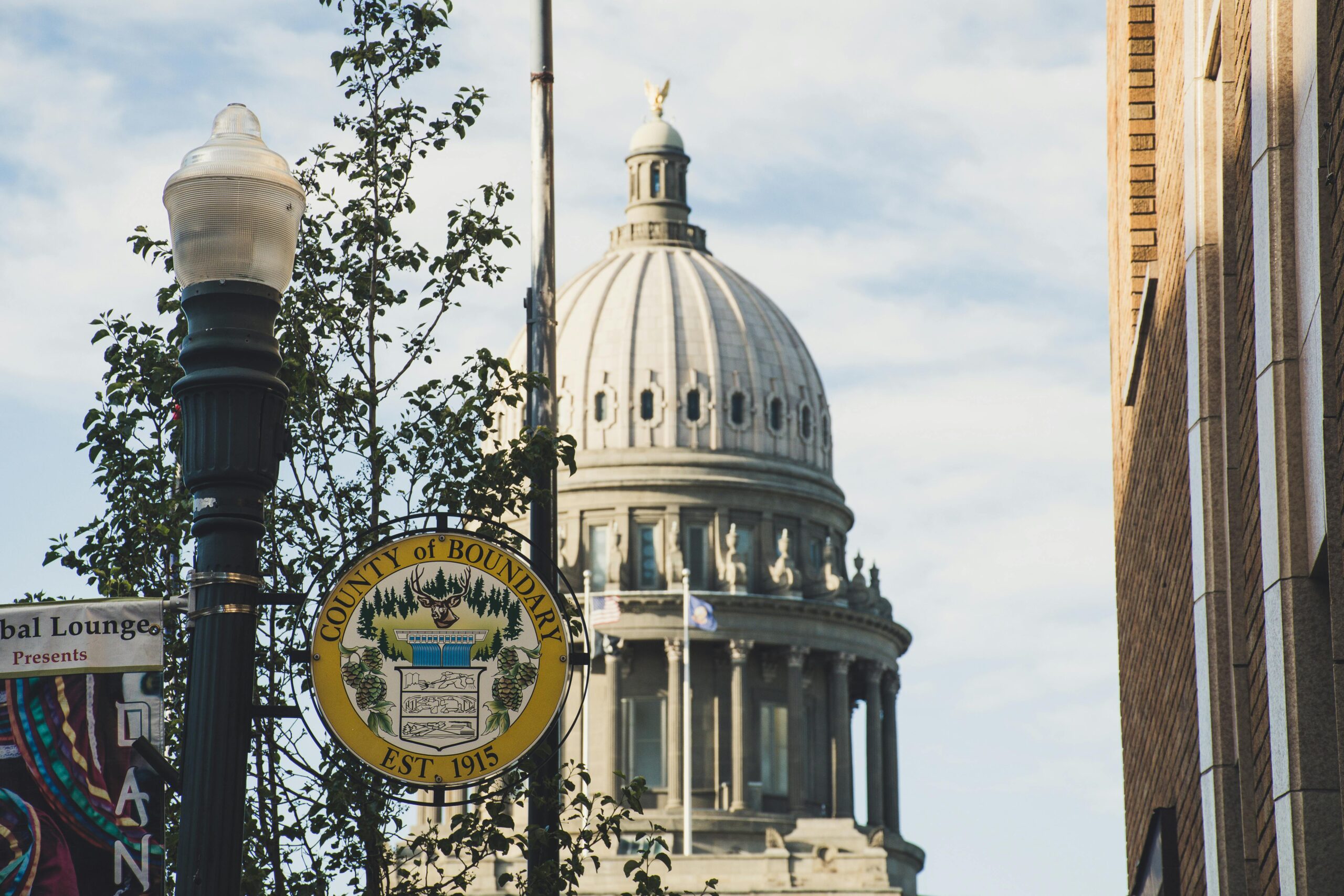Iconic dome of Boundary County Courthouse set against clear sky, with street sign in foreground.
