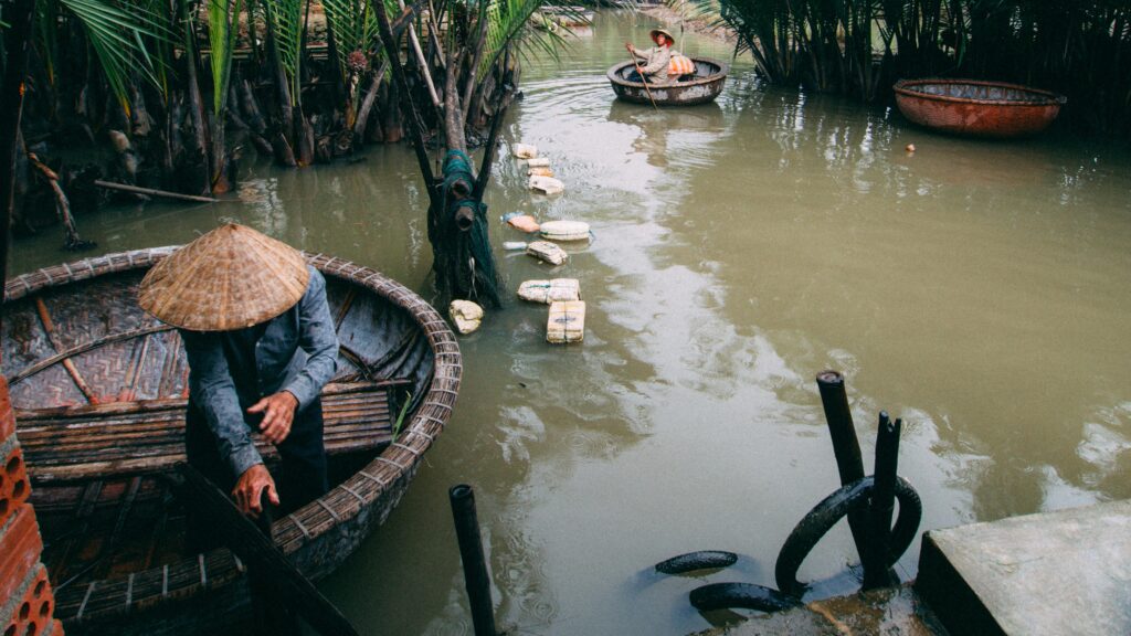 Men rowing traditional basket boats in rural Vietnam's lush waterways.
