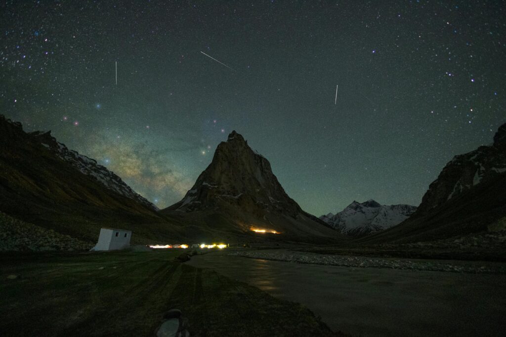 Breathtaking view of Zanskar with starry night sky and towering mountains, perfect for adventure and travel enthusiasts.