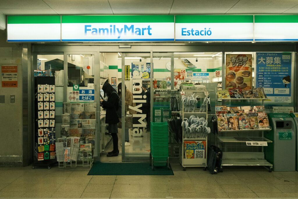 FamilyMart entrance with merchandise and people in Toyota, Japan.