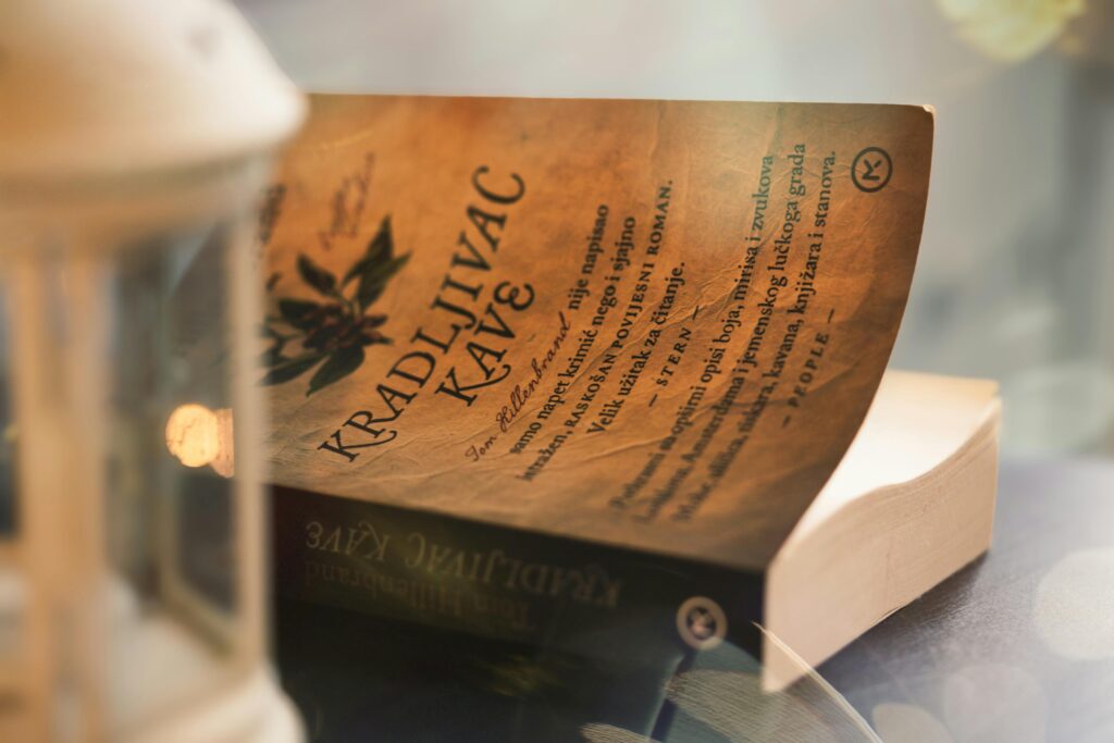 Close-up of a vintage book page with warm light and lantern ambiance.