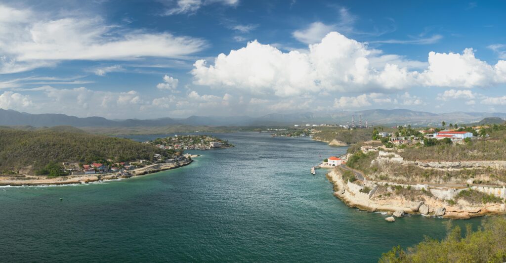 A breathtaking aerial view of Santiago de Cuba's coastal landscape under a bright blue sky.