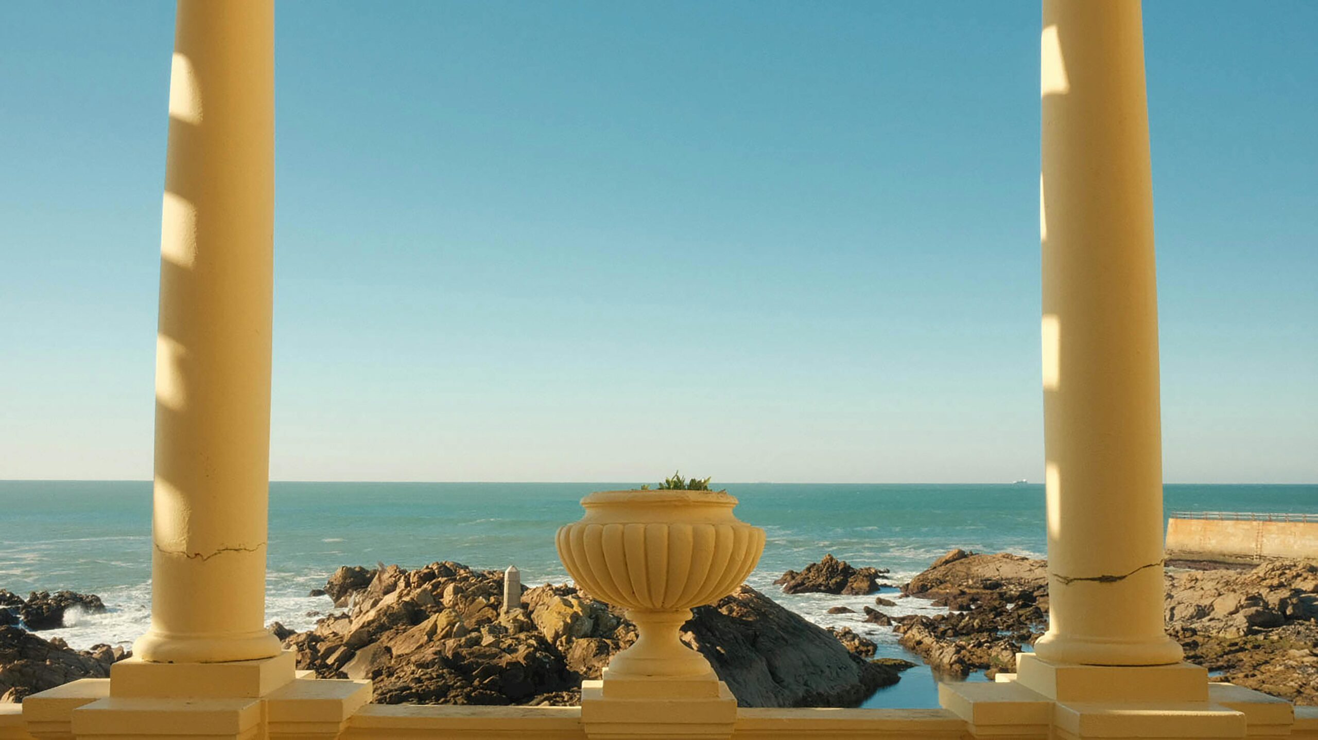 Tranquil scene overlooking the ocean from a colonnade in Foz do Douro, Porto, Portugal.