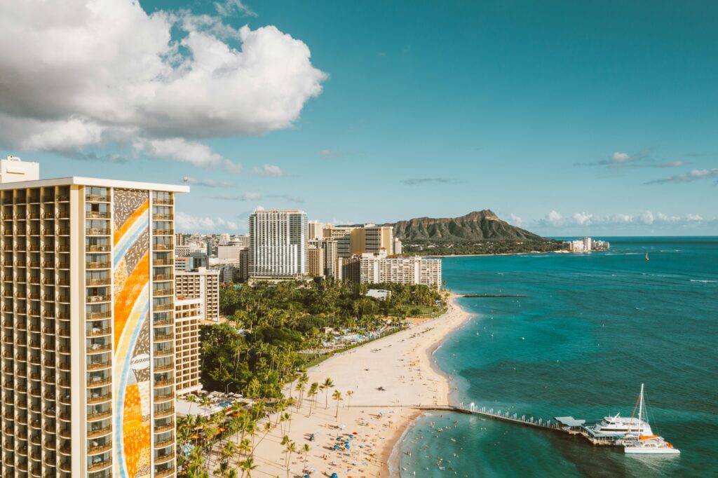 Stunning aerial view of Waikiki Beach with Diamond Head in the background under a blue sky.