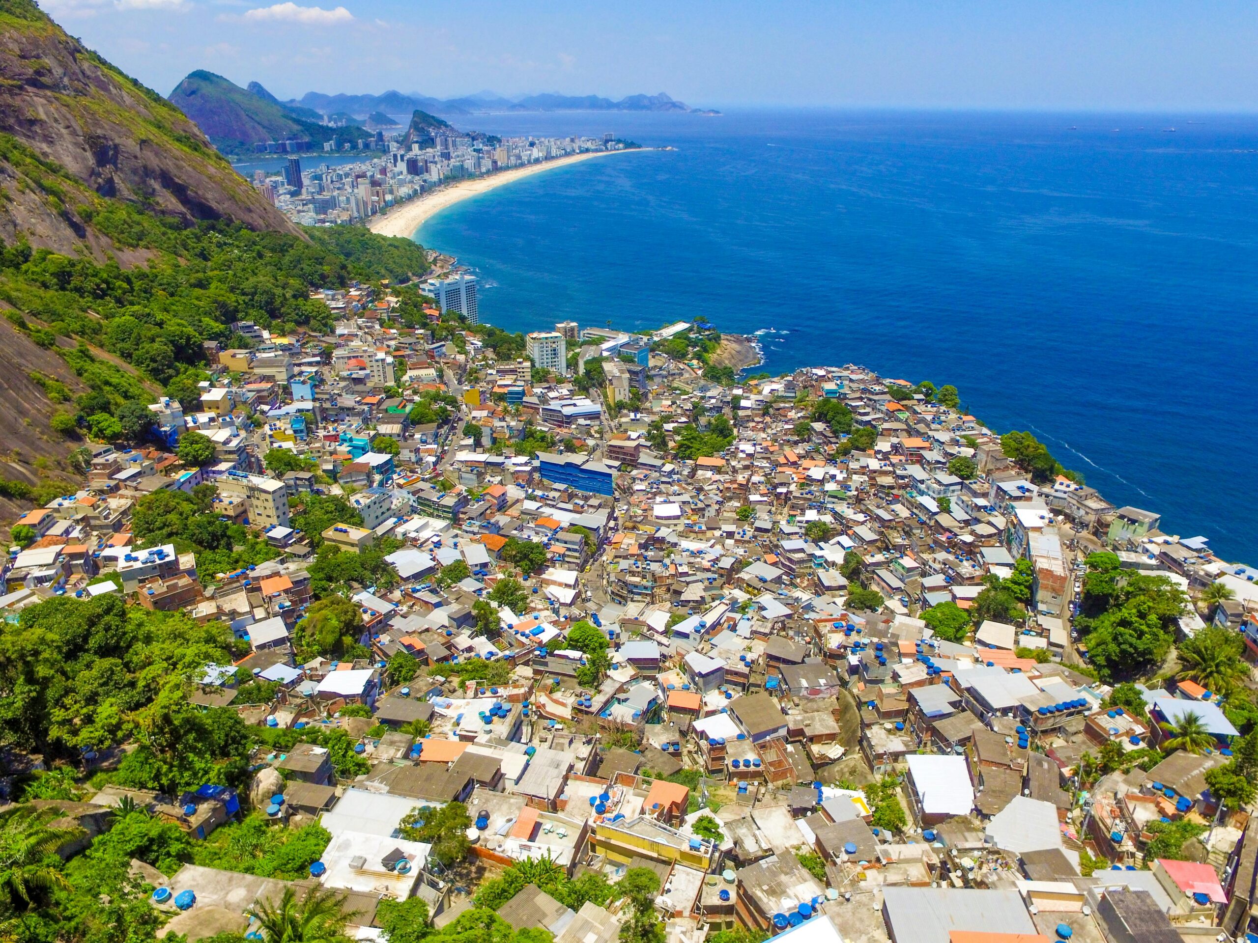 Stunning aerial view of Rio de Janeiro's favela contrasting with the blue coastline and scenic cityscape.