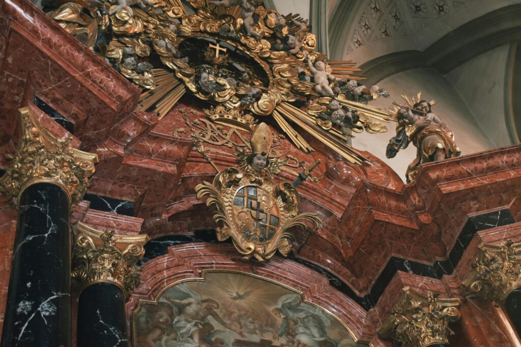 Intricate Baroque decorations with gold accents in a historic church interior.