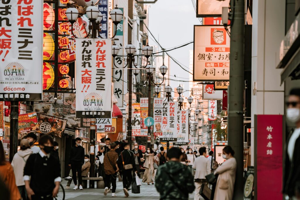Bustling street scene in Dotonbori, Osaka, showcasing vibrant signages and a lively atmosphere.