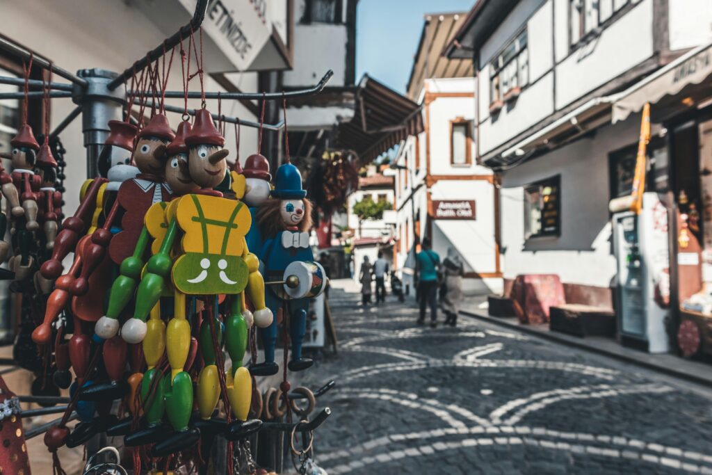 Vibrant wooden toys hanging in a charming cobblestone street market in Amasya, Turkey.