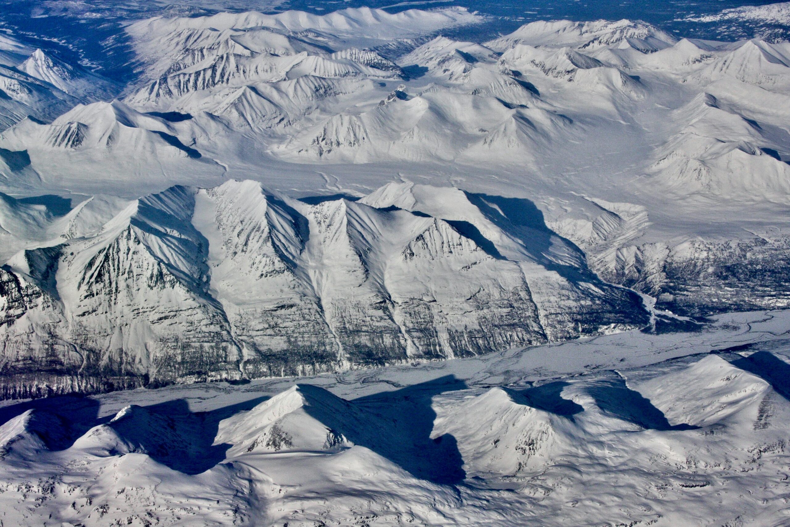 Stunning aerial shot of snow-capped mountains in Alaska, showcasing pristine winter landscapes.