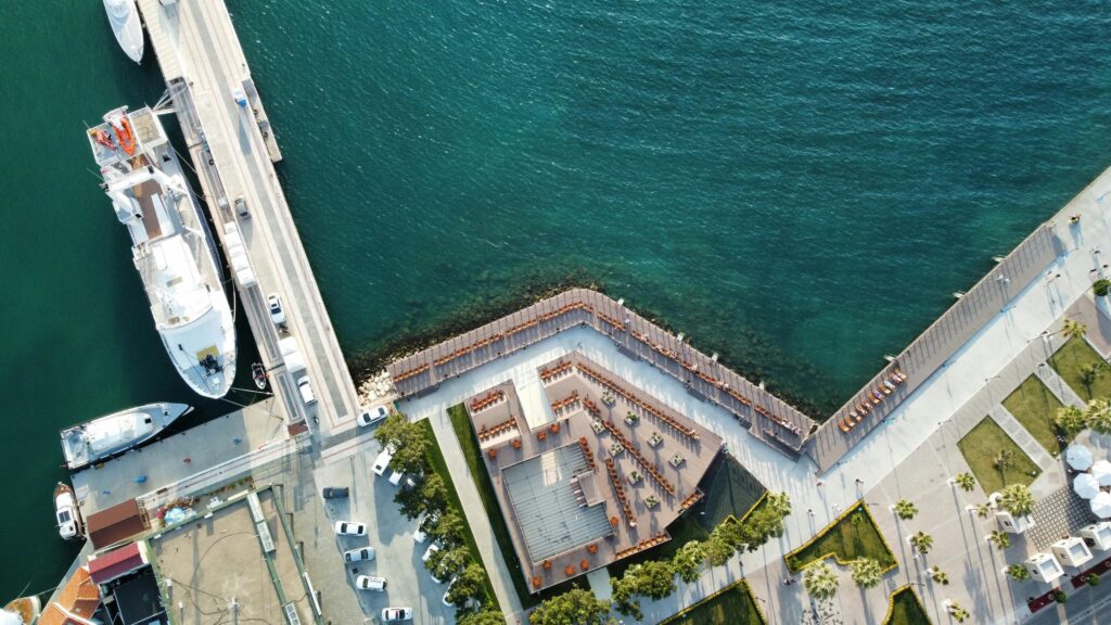 A stunning aerial shot of a coastal harbor with boats, walkways, and clear blue waters.