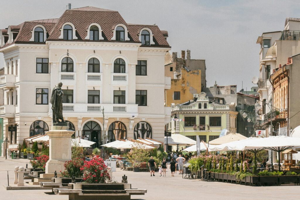 Historic square in Constanța, Romania with classic architecture and outdoor cafes.