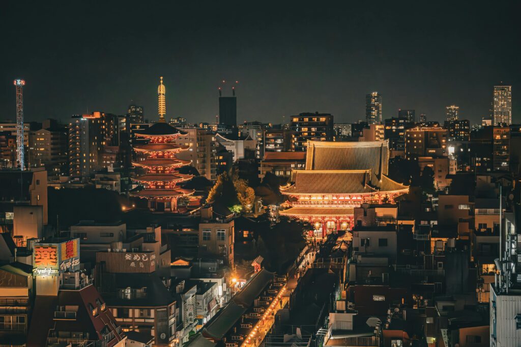 Stunning nighttime aerial view of Senso-ji Temple and Tokyo skyline in Taito City, Japan.