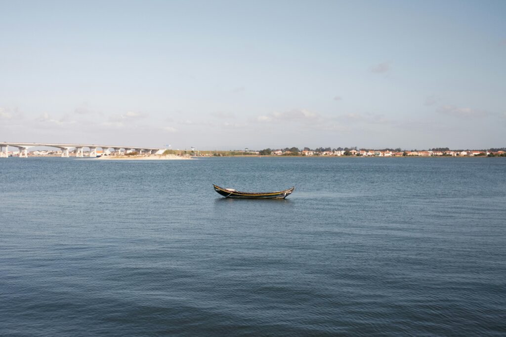Peaceful scene of a traditional boat on calm waters in Aveiro, Portugal.