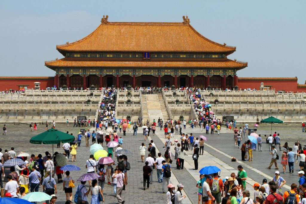 Crowds visiting the historic Forbidden City in Beijing, China on a sunny day.