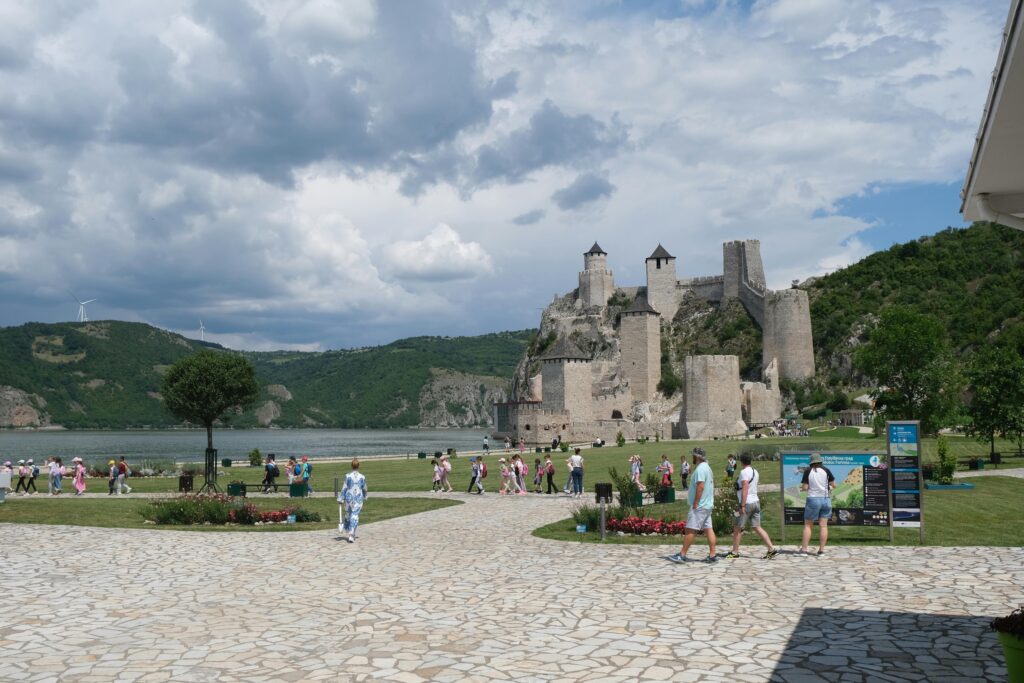 Scenic view of Golubac Fortress with tourists exploring the historic site in Serbia.