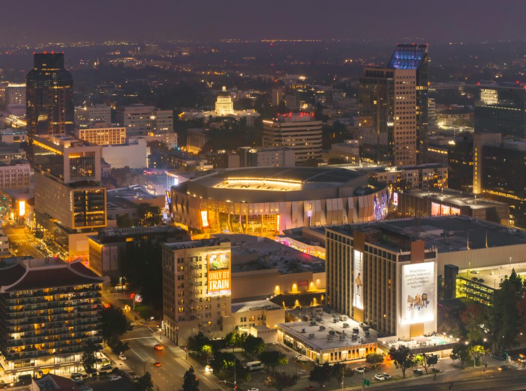 Dazzling aerial shot of downtown Sacramento showcasing the Golden 1 Center amid the vibrant cityscape at night.