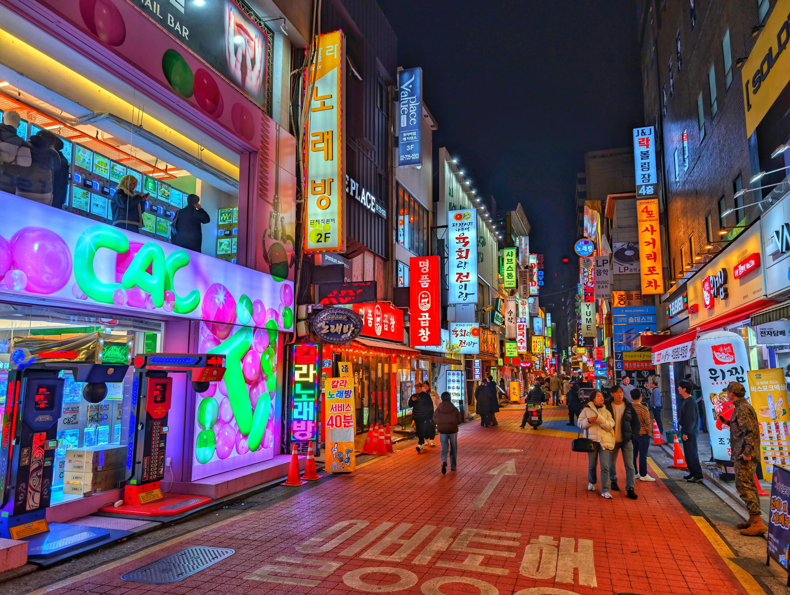 Explore the vibrant nightlife of Seoul's bustling street with colorful neon signs and lively atmosphere.