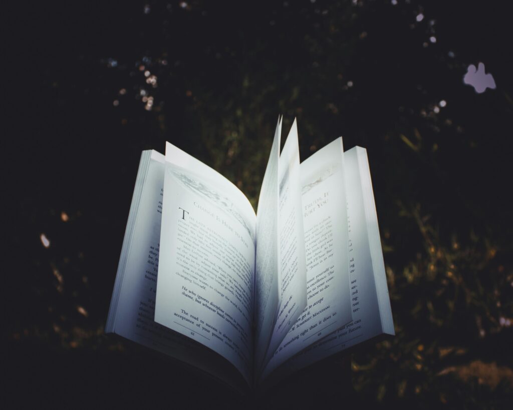 An open book with pages turning, captured outdoors, creating a dreamy reading atmosphere.