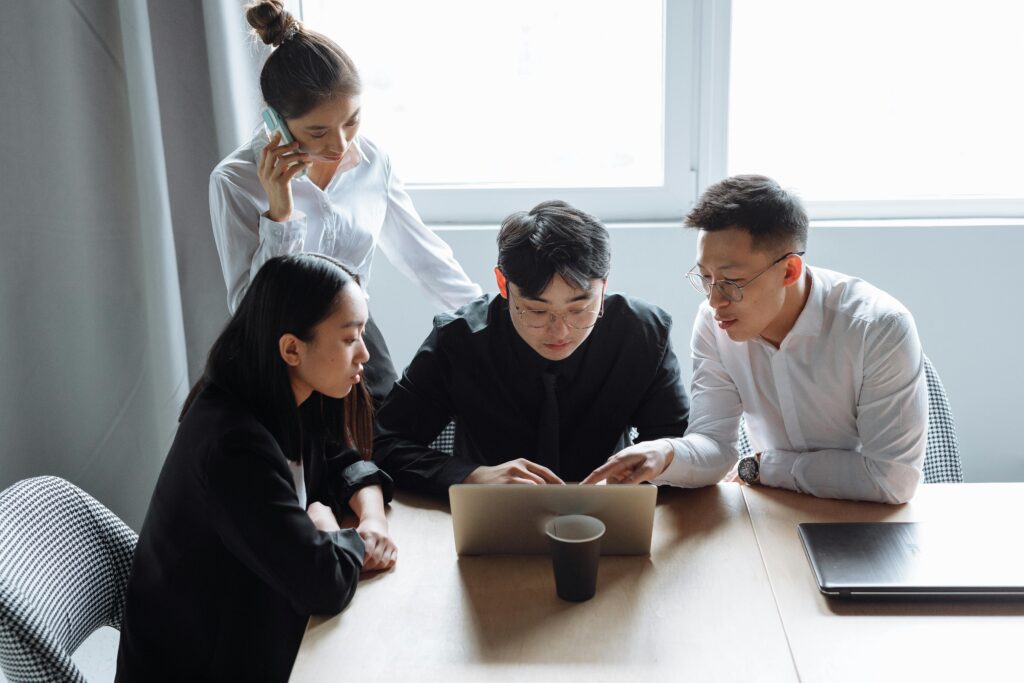 Business team brainstorming in an office setting with laptops and teamwork spirit.