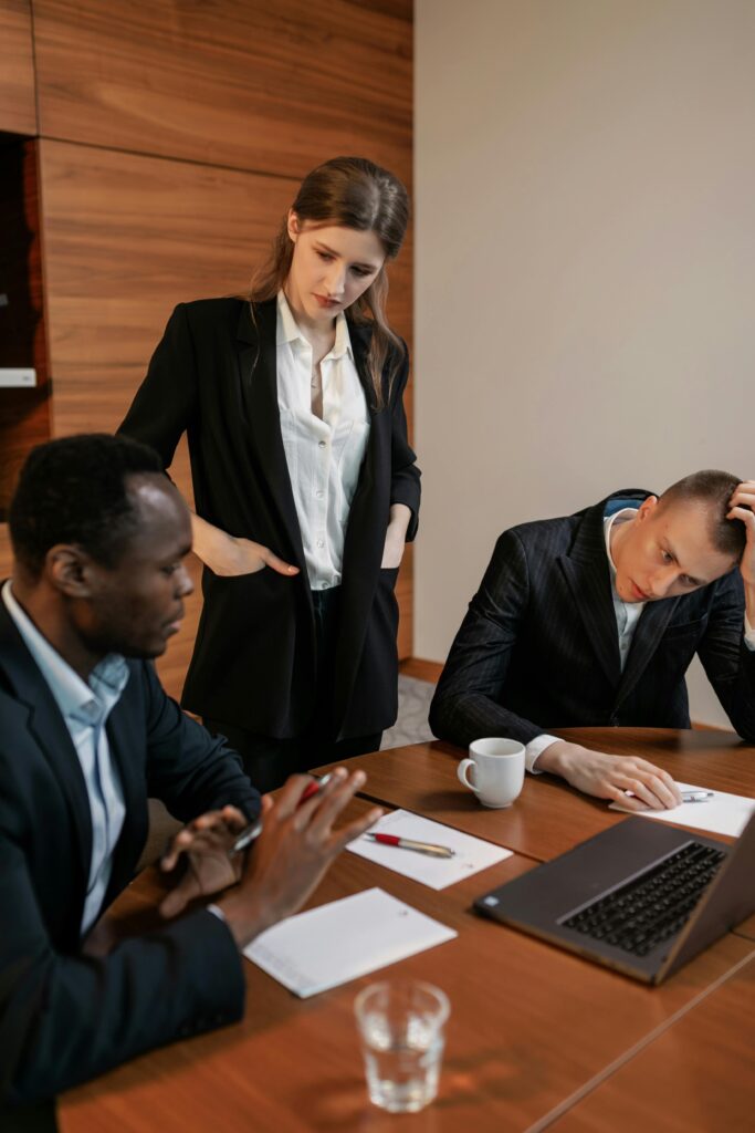 Diverse group of professionals engaged in a serious meeting, emphasizing teamwork and leadership in a modern office setting.