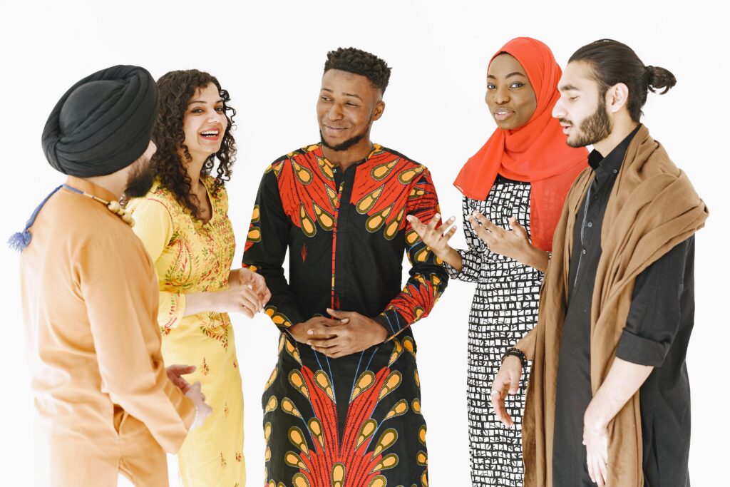 Multicultural group of adults in traditional attire gathered and conversing energetically.