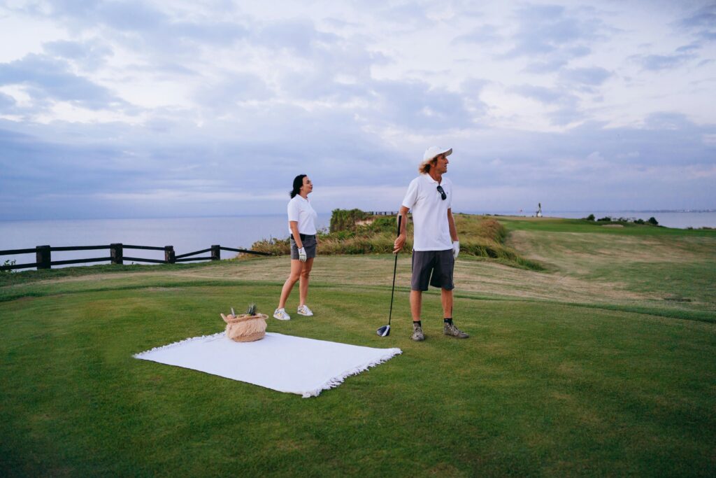 Two golfers enjoying a relaxing game by the ocean with a picnic, embracing leisure and lifestyle.