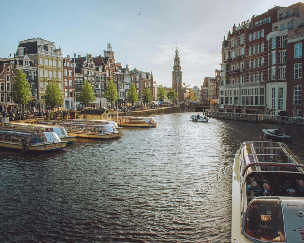 Charming view of Amsterdam's canals with tour boats and historic buildings, capturing the essence of the city.