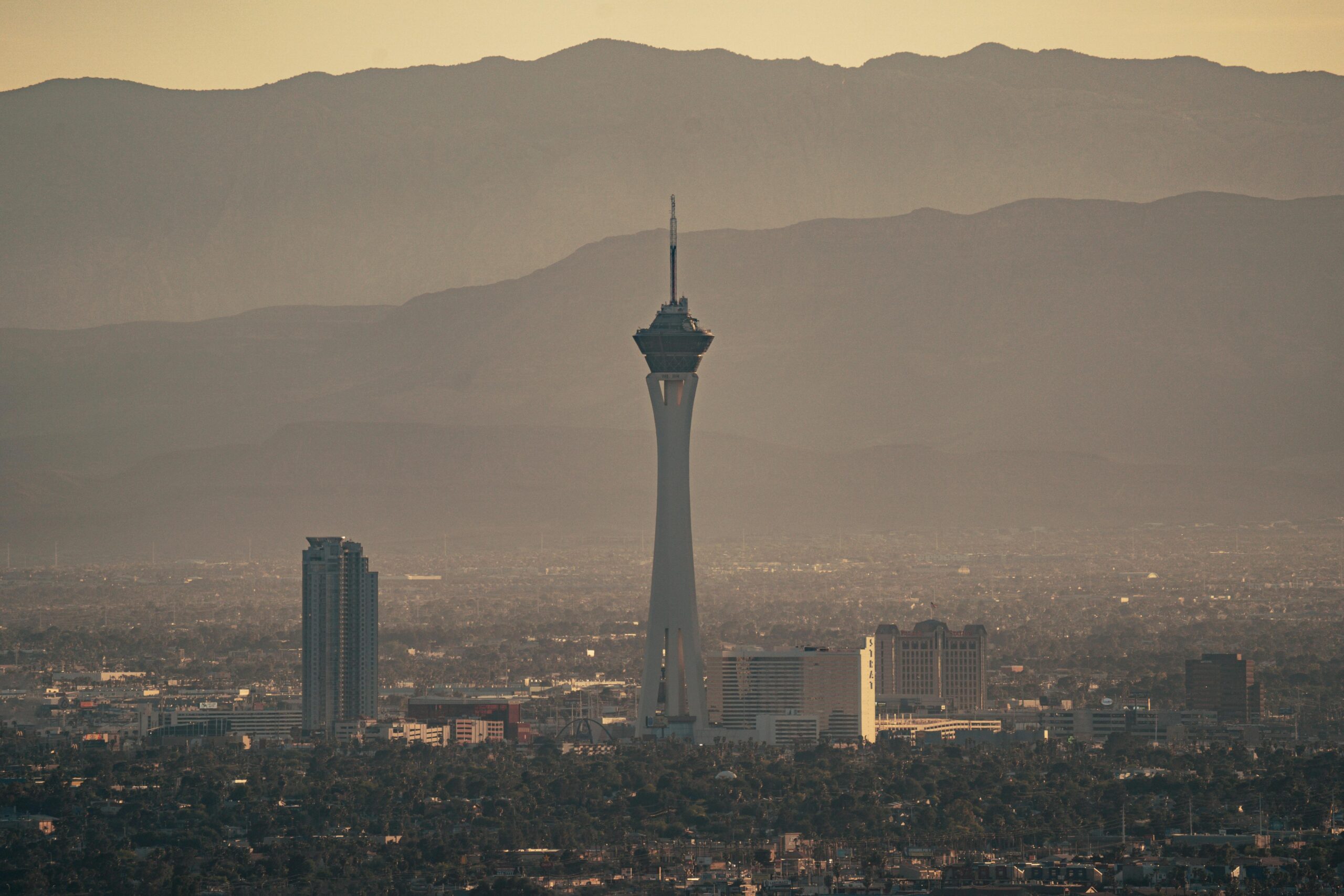 Aerial view of the Stratosphere Tower amidst Las Vegas cityscape during twilight.