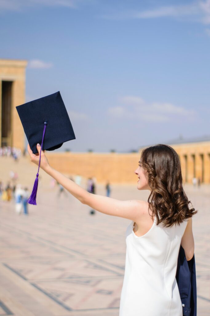 A woman celebrating graduation with an academic cap at Anıtkabir, Ankara.