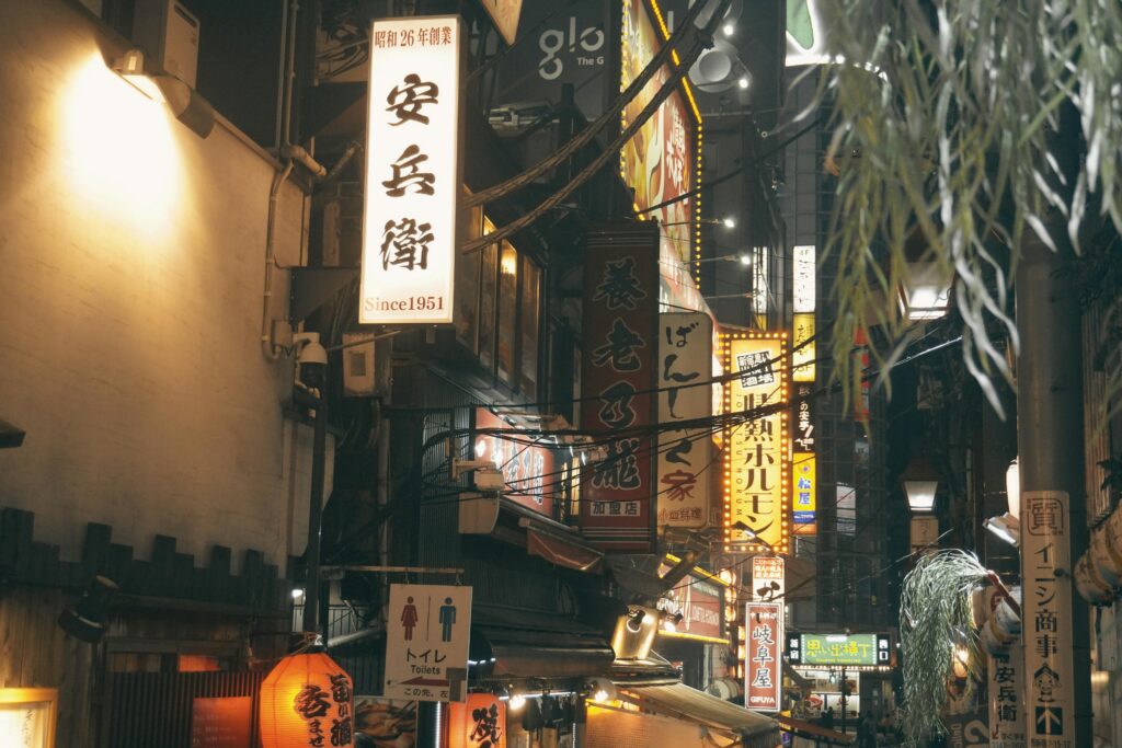 Illuminated Tokyo street with vibrant signs at night, showcasing urban Japan.