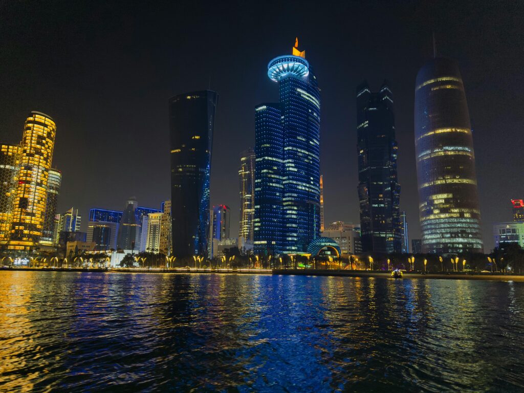 Captivating night scene of Doha's illuminated skyline reflecting on water in Qatar.