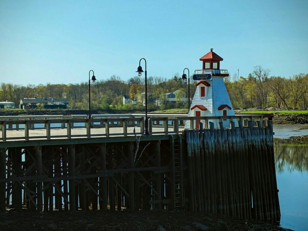 Picturesque scene of a riverside lighthouse with a boardwalk, perfect for travel and outdoor themes.